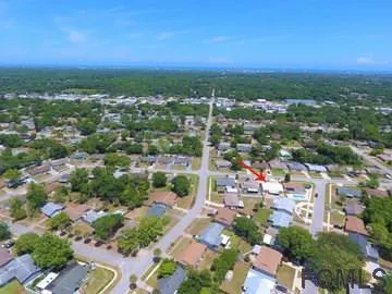 an aerial view of residential houses with outdoor space and trees