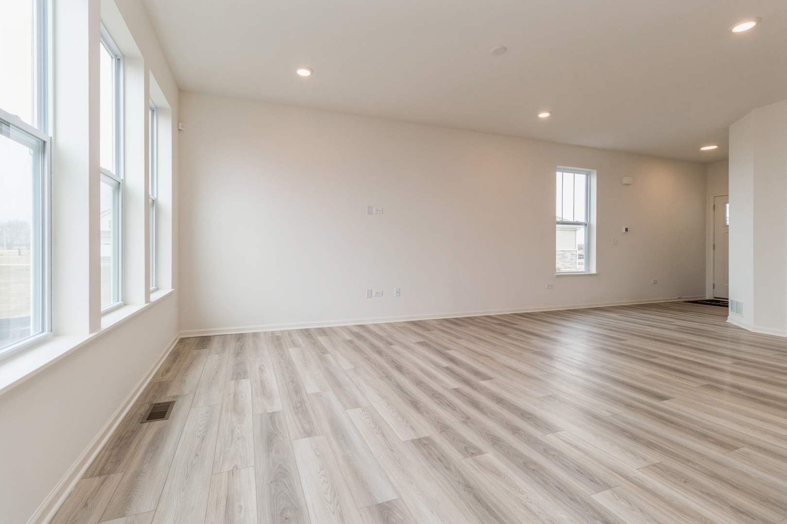 25624 West Springview Drive Plainfield, IL 60586 - Photo 6 of 22 an empty room with wooden floor and windows