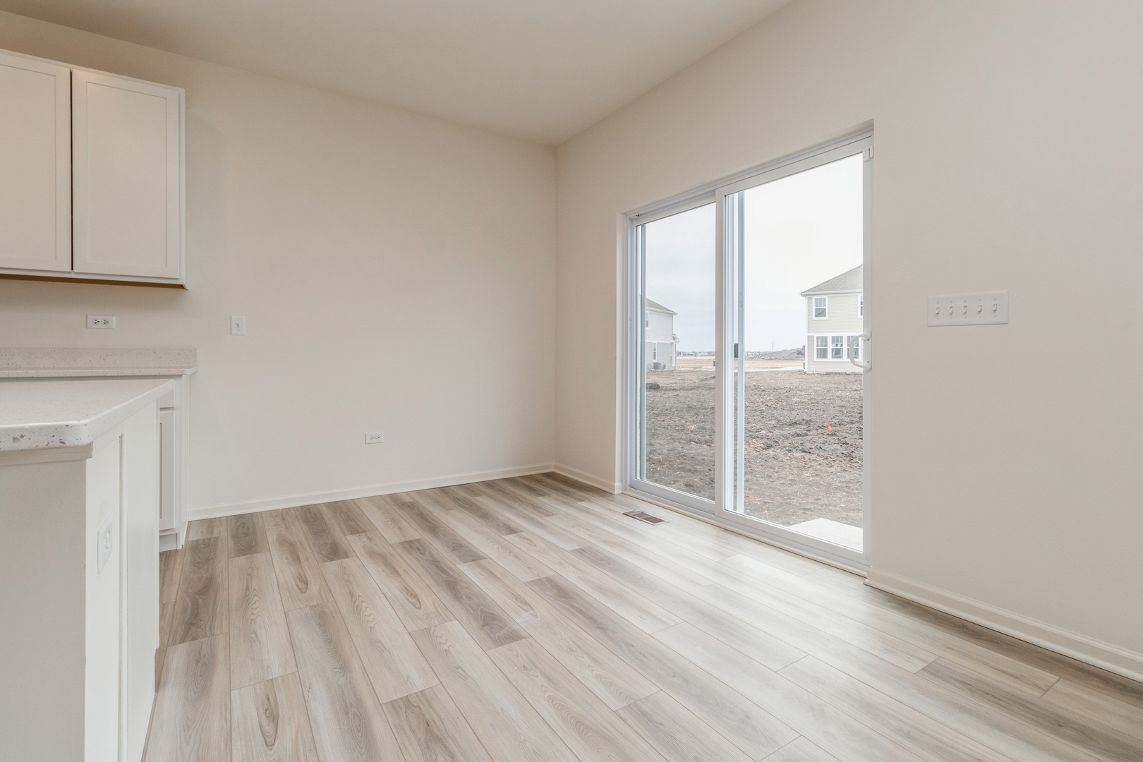 25624 West Springview Drive Plainfield, IL 60586 - Photo 7 of 22 an empty room with wooden floor and windows