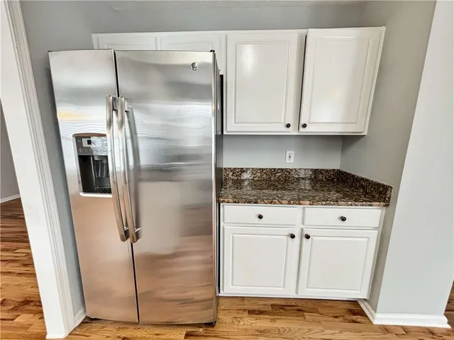 a kitchen with granite countertop a refrigerator and a sink