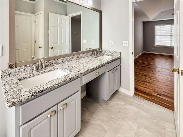 a bathroom with a granite countertop sink and a mirror