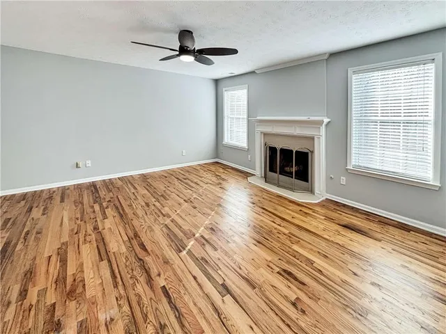 a view of a livingroom with wooden floor and a fireplace