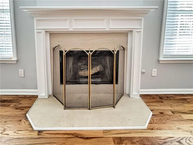 a view of a livingroom with wooden floor and a fireplace
