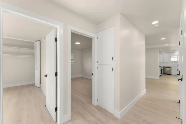 a kitchen with stainless steel appliances a stove a white cabinets and a potted plant