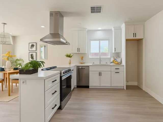 a kitchen with stainless steel appliances a stove a sink and a refrigerator