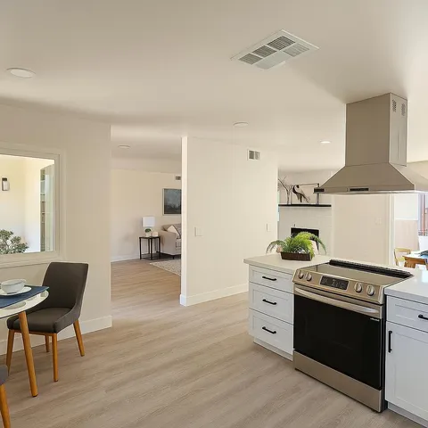 a dining room with furniture a large window and a chandelier