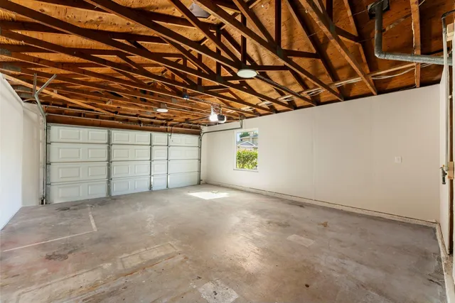 a view of a backyard with wooden fence and a large tree
