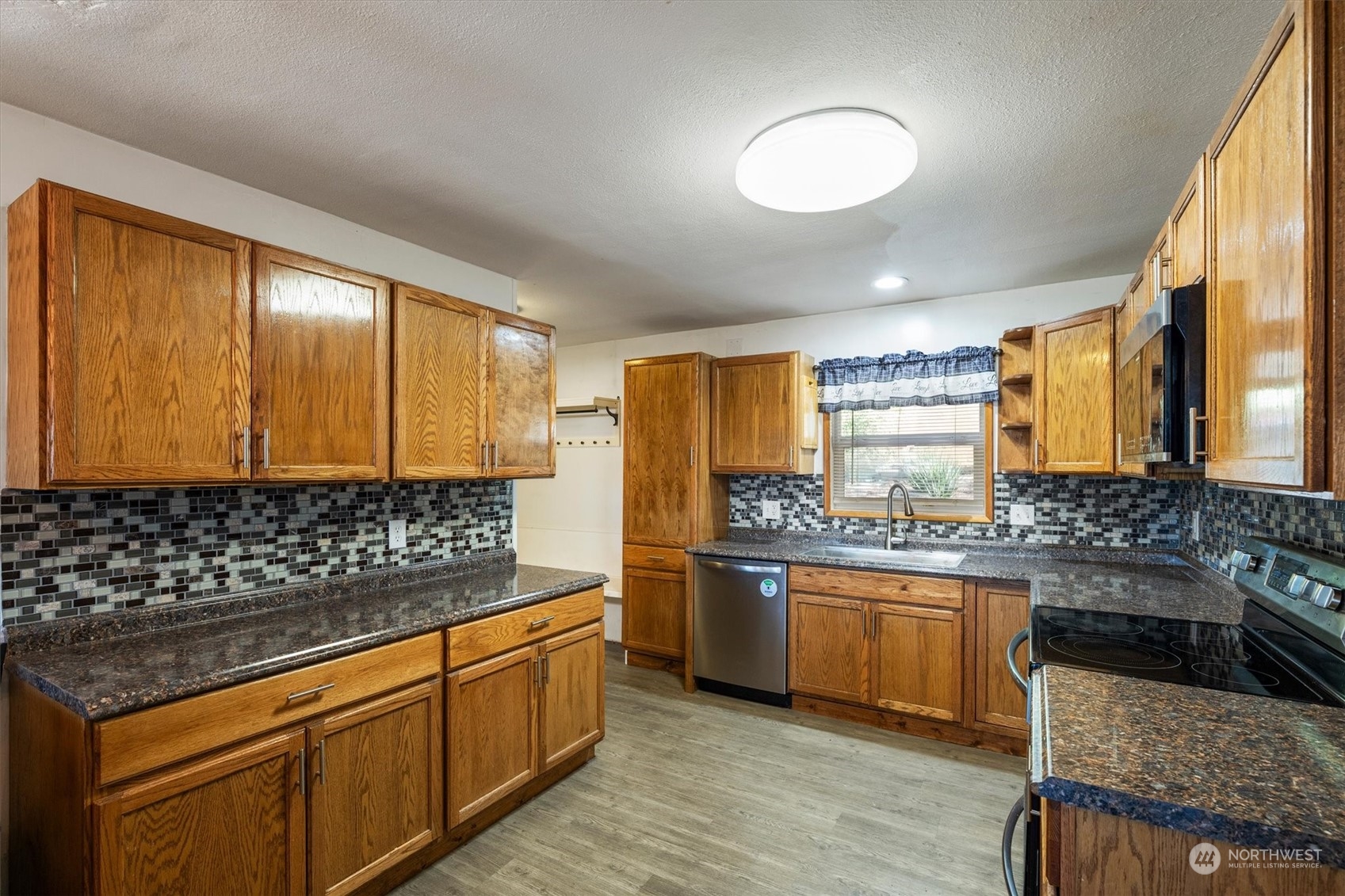 3827 Sunset Way Longview, WA 98632 - Photo 14 of 40 a kitchen with stainless steel appliances granite countertop a stove a sink and a refrigerator