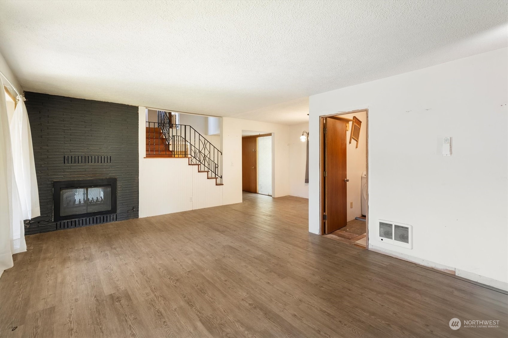 3827 Sunset Way Longview, WA 98632 - Photo 10 of 40 a view of an empty room with wooden floor and a fireplace
