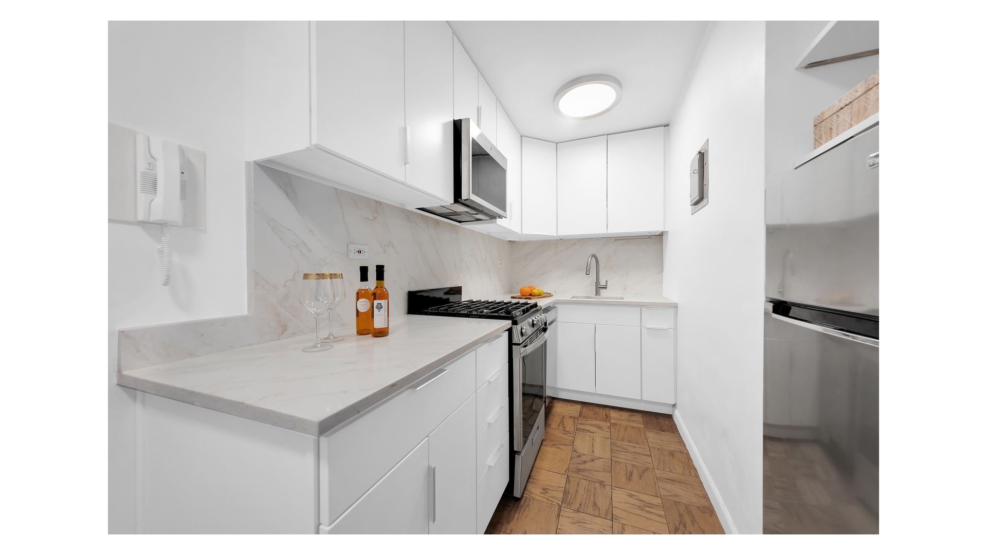310 West 56th Street, Unit 10F Manhattan, NY 10019 - Photo 3 of 6 a kitchen with cabinets and wooden floor