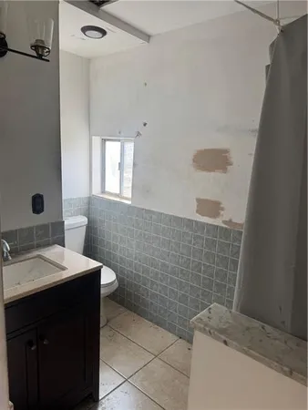 a bathroom with a granite countertop sink a toilet and mirror