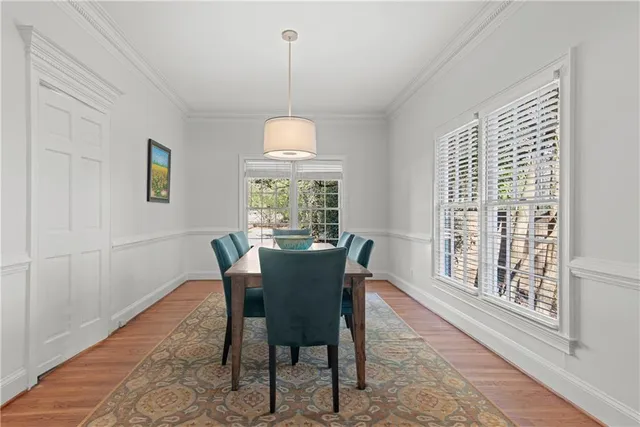 a view of a dining room with furniture a chandelier and wooden floor