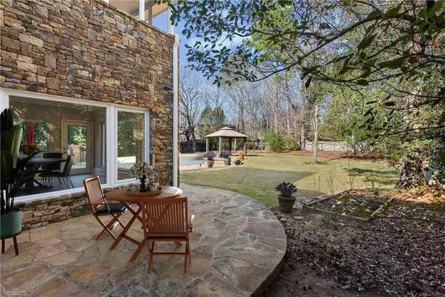 a view of a house with backyard and sitting area
