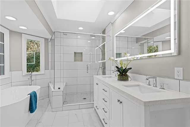 a bathroom with a double vanity sink mirror and bathtub