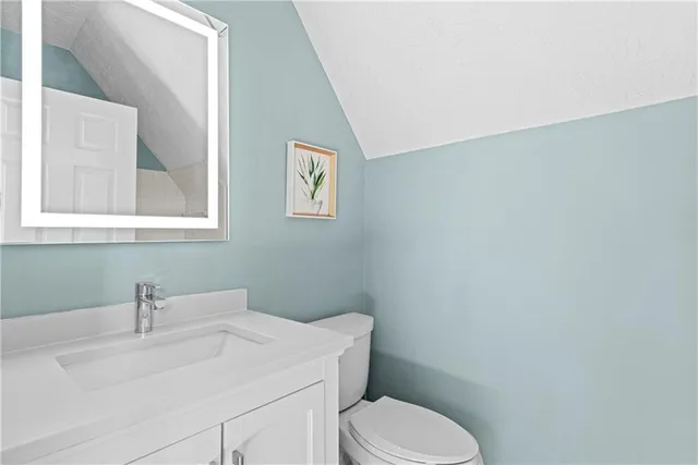 a bathroom with a sink mirror vanity and toilet