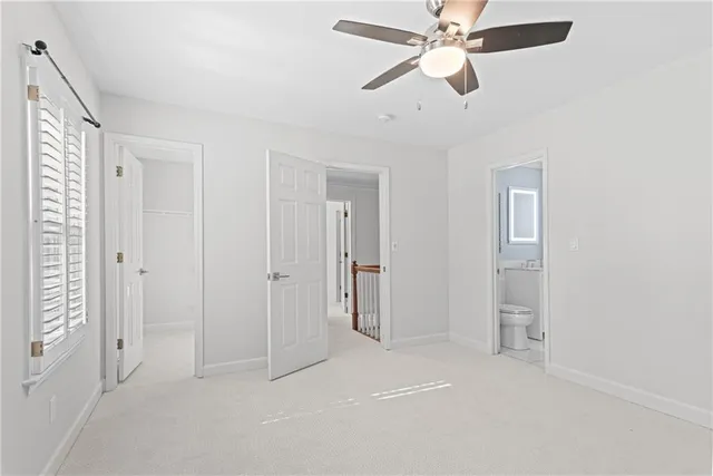 an empty room with closet and a chandelier fan