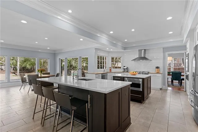 a kitchen with stainless steel appliances granite countertop table chairs sink and stove