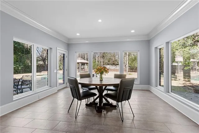 a dining room with furniture and large windows