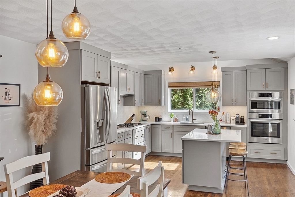 a kitchen with stainless steel appliances a dining table chairs and chandelier