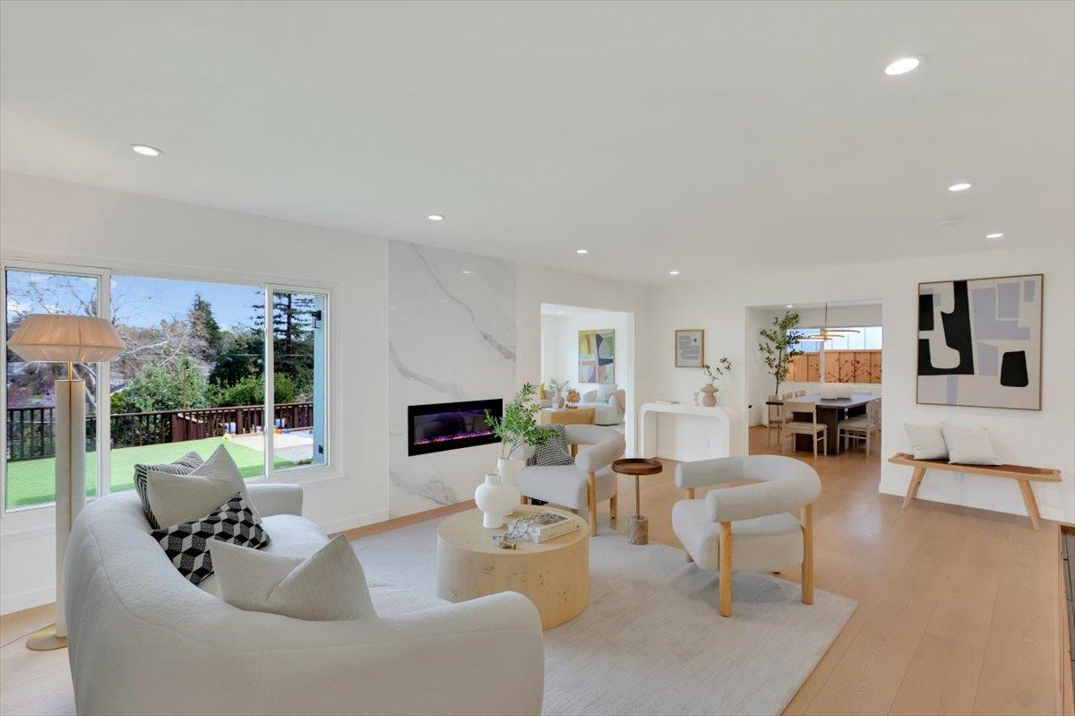 a living room with fireplace furniture and a large window