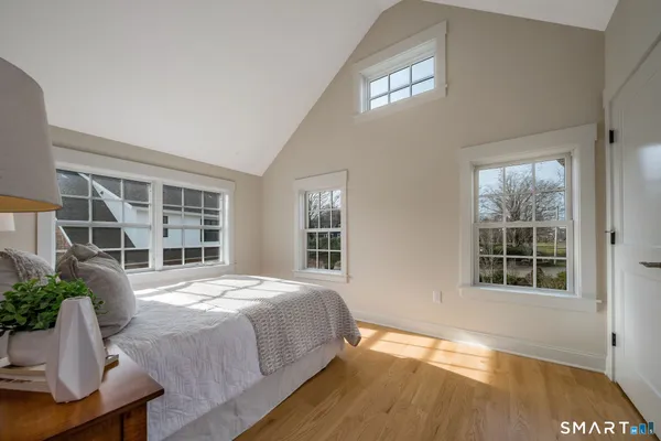 a view of a bedroom with wooden floor and windows