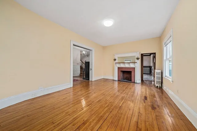 a view of a livingroom with wooden floor and a fireplace