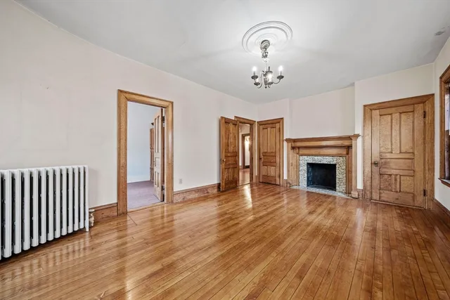 a view of a livingroom with wooden floor and a fireplace