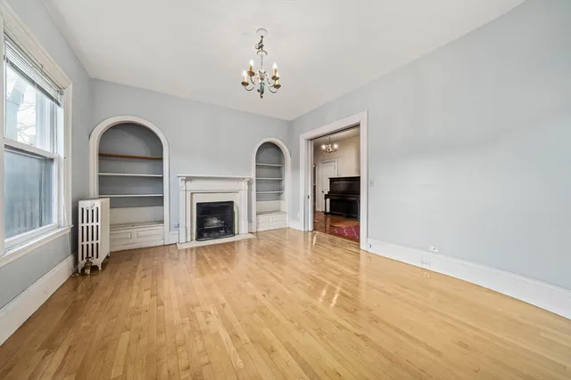 wooden floor fireplace and windows in an empty room