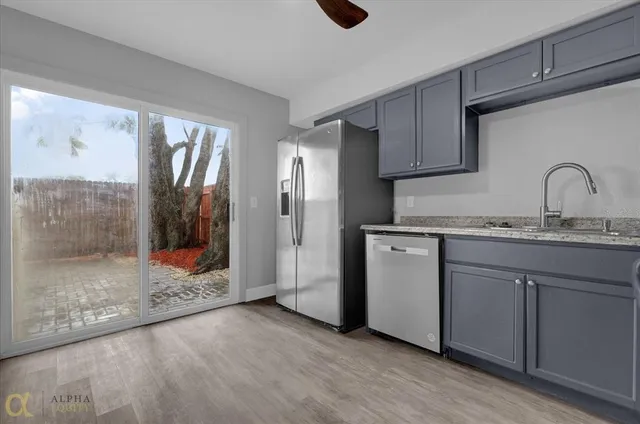 a kitchen with stainless steel appliances granite countertop a refrigerator and a sink