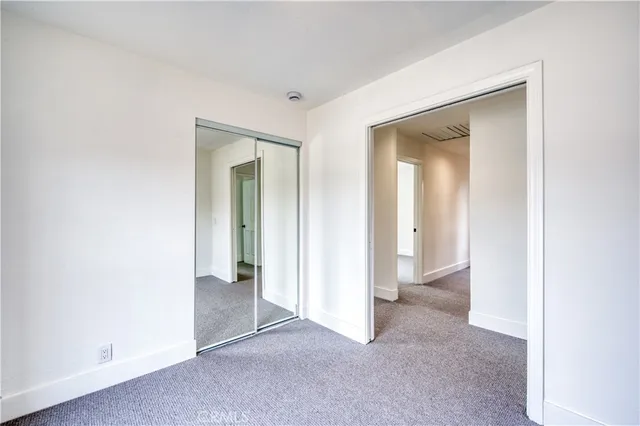 an empty room with closet and a bathroom