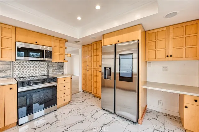 a kitchen with stainless steel appliances granite countertop a refrigerator and a stove top oven