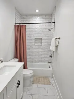 a bathroom with a shower a toilet and sink