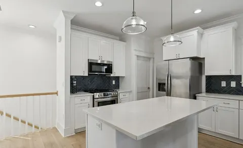 a kitchen with stainless steel appliances a refrigerator sink and microwave
