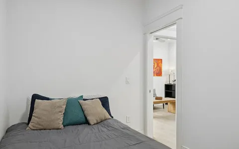 a bed sitting in a bedroom next to a bathroom