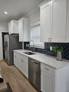 a kitchen with white cabinets and stainless steel appliances