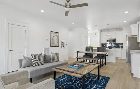 a living room with furniture and kitchen view