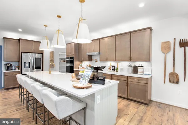 a kitchen with stainless steel appliances kitchen island granite countertop a sink a stove and refrigerator