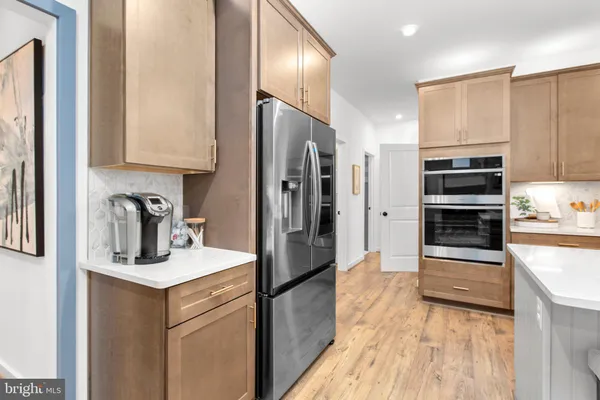 a kitchen with stainless steel appliances granite countertop a refrigerator and a stove top oven