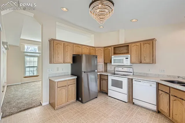 a kitchen with stainless steel appliances granite countertop a refrigerator stove and sink