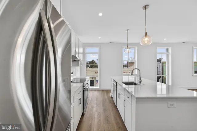 a kitchen with stainless steel appliances a refrigerator a sink and dishwasher