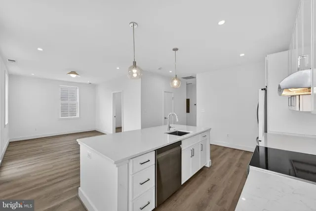 a kitchen with a sink stove and wooden floor