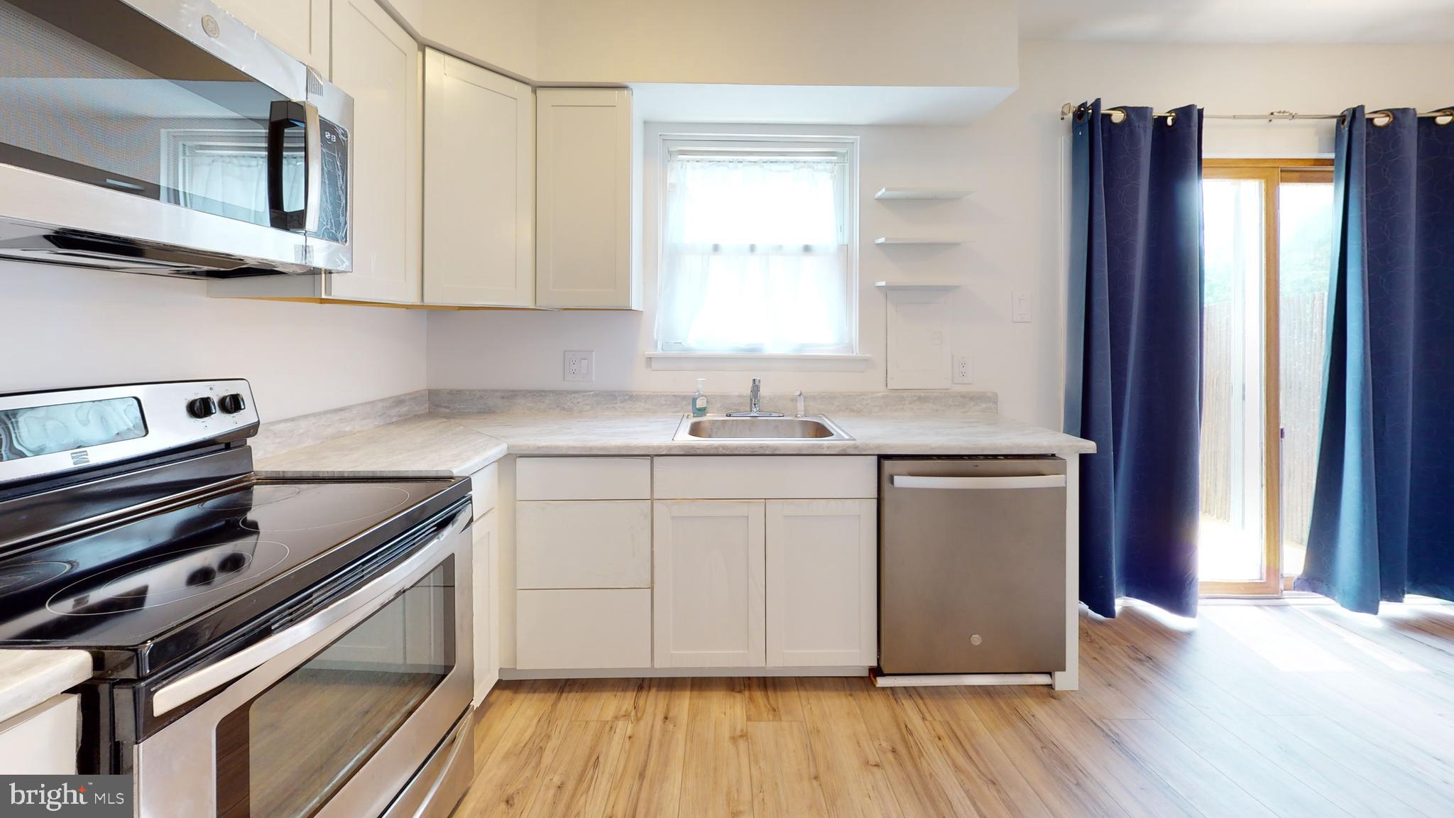 49 Eaves Mill Road Medford, NJ 08055 - Photo 36 of 38 a kitchen with stainless steel appliances granite countertop a refrigerator a sink dishwasher a stove and white countertops with wooden floor