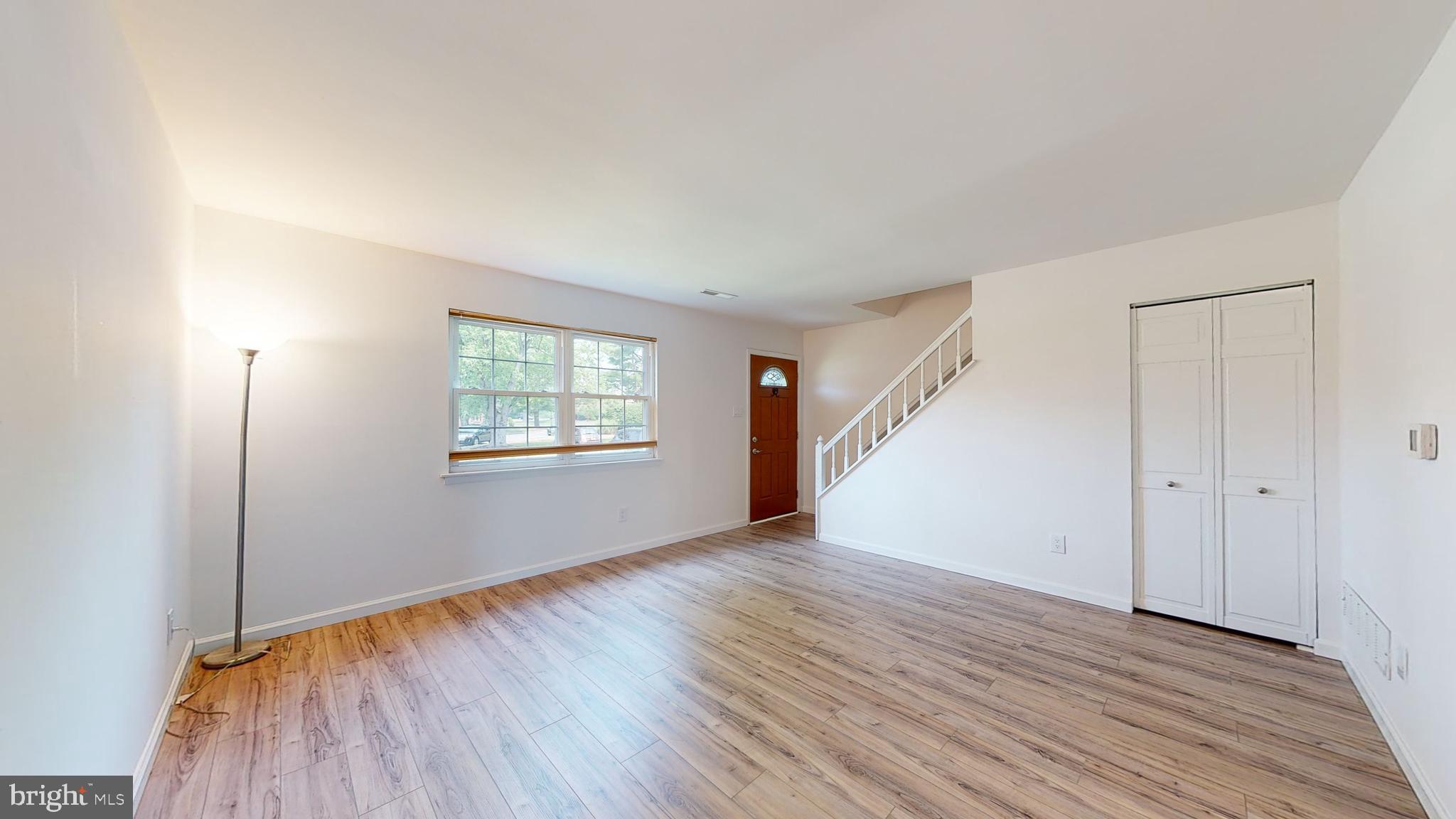 49 Eaves Mill Road Medford, NJ 08055 - Photo 9 of 38 an empty room with wooden floor staircase and windows