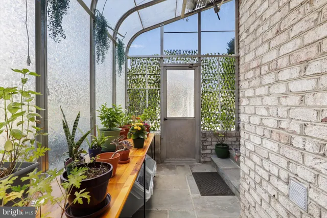 a view of a patio with table and chairs potted plants with floor to ceiling window