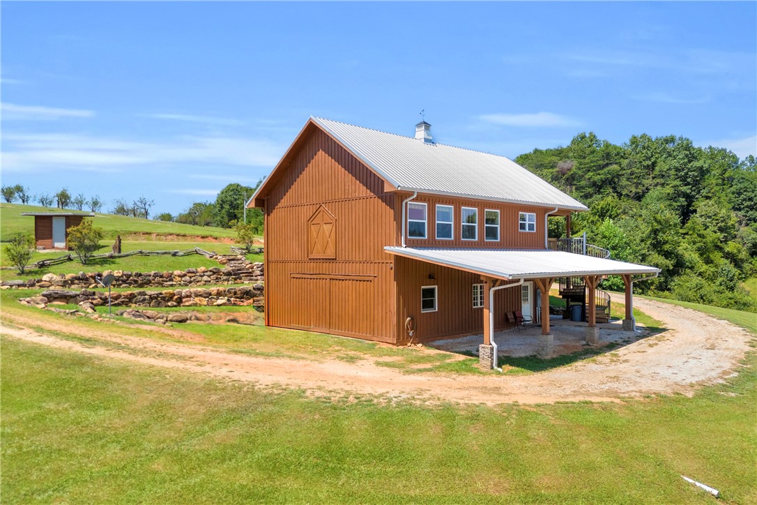 498 Raines Road Mountain Rest, SC 29664 - Photo 26 of 48 Metal roofing and rustic vertical siding define this versatile multi-level barn nestled on a grassy hillside.