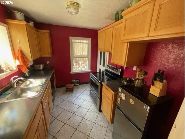 a kitchen with a sink dishwasher and a refrigerator