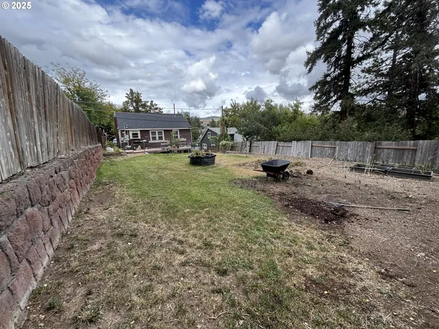 a view of a house with backyard and sitting area