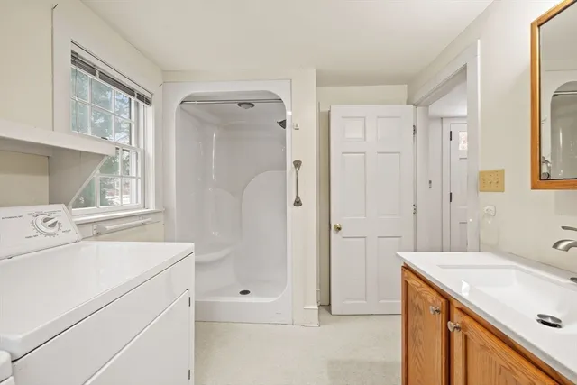 a bathroom with a sink vanity granite and a shower