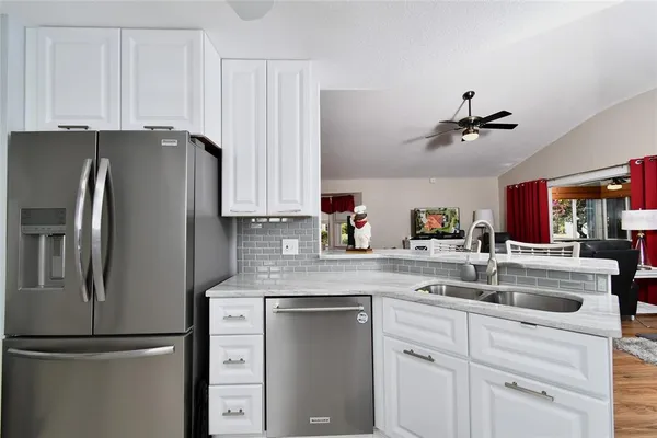 a kitchen with appliances a sink and cabinets