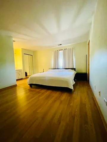 a bedroom with a bed and wooden floor